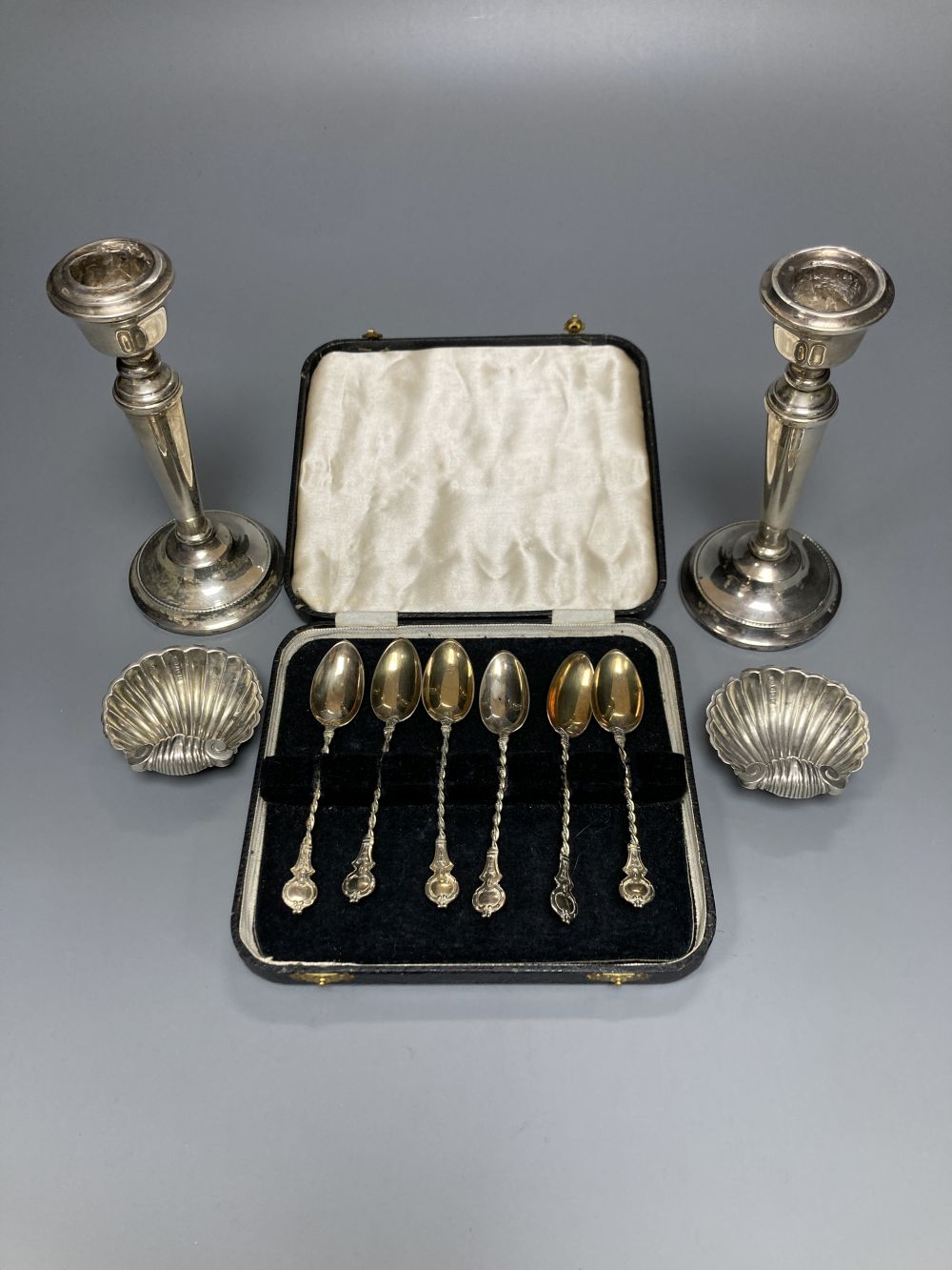 A pair of modern silver candlesticks, 15.6cm, weighted, a pair of George V silver shell salts and six coffee spoons